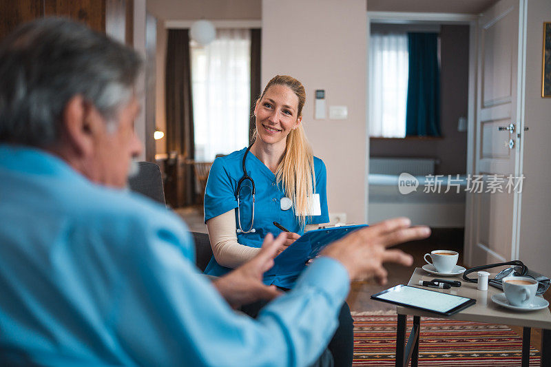 快乐的白人护士在家里检查一位老年白人病人