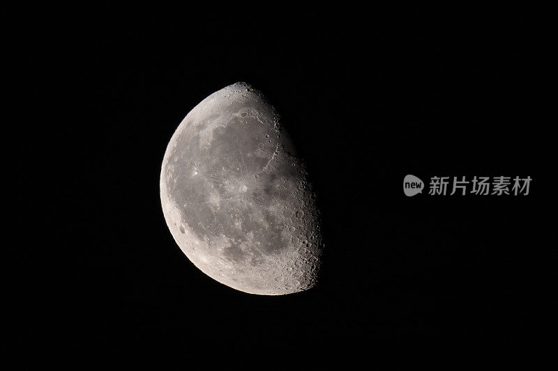 在黑暗的夜空中，月亮表面清晰可见。