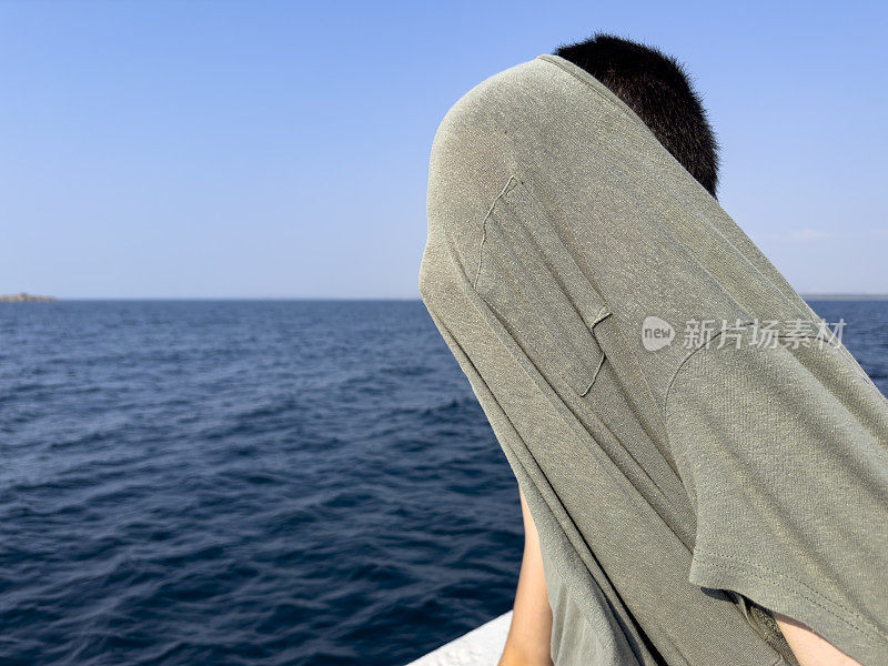 这个男孩正在北爱琴海的一艘男孩游船上旅行。体贴又快乐。晴朗的夏日。旅游的背景。旅游的概念。