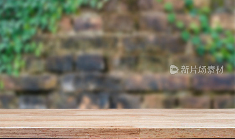 砖墙背景上的空木桌