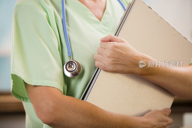 女医生或护士手持病人的病历、x光片。