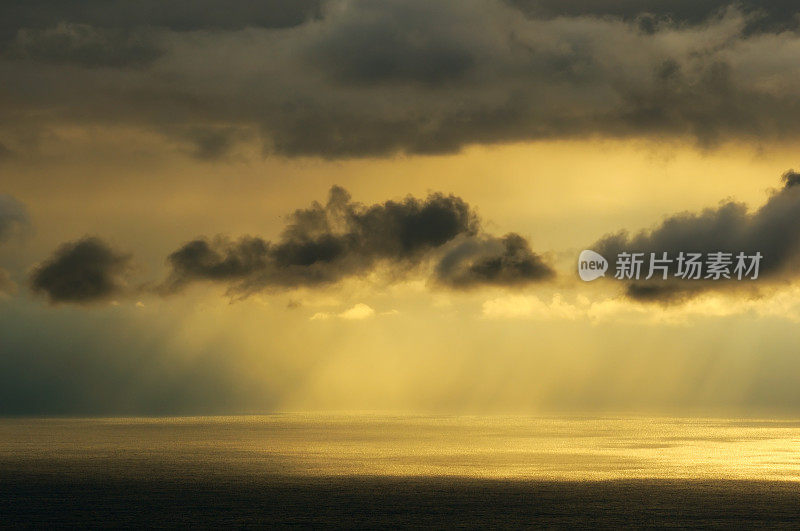 阳光在多云的天空在海上