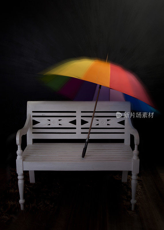 白色长凳和彩色雨伞