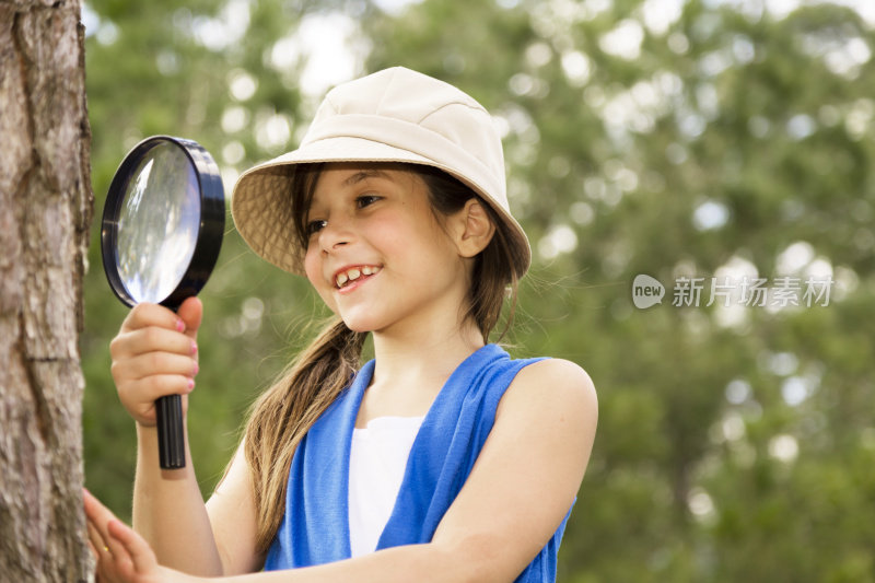 小学女孩喜欢发现自然。放大镜。