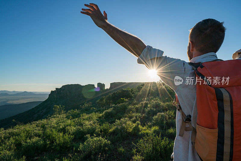 年轻人在山顶上张开双臂