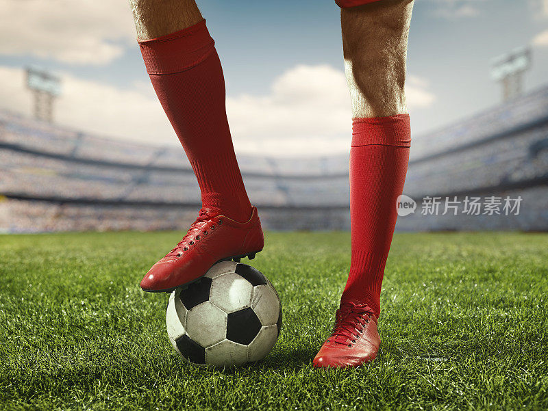 足球运动员的腿在足球上