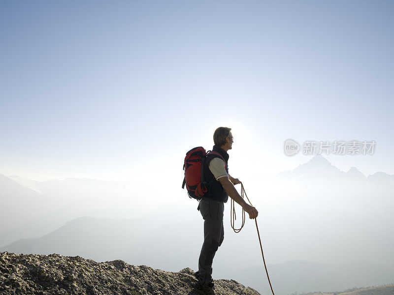 登山者站在山顶上抓着绳子