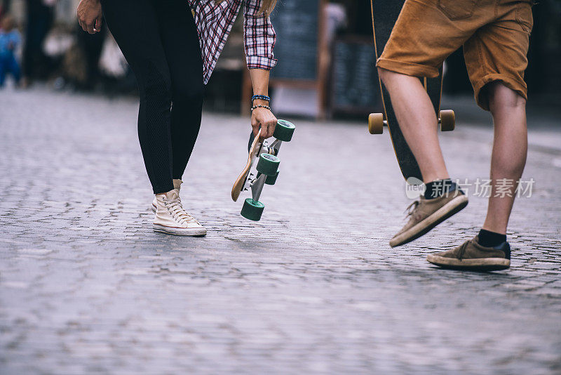 一对年轻夫妇在城市街道上玩滑板