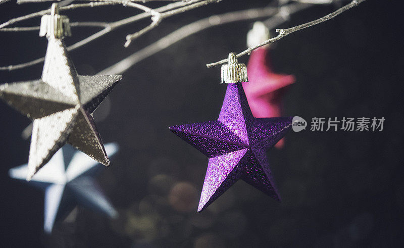 圣诞星星饰品挂在银枝上，用散蜡装饰