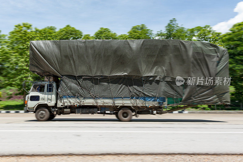 在泰国的高速公路上，一辆超载的卡车正在高速行驶。