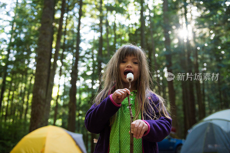 女孩在露营时享受棉花糖