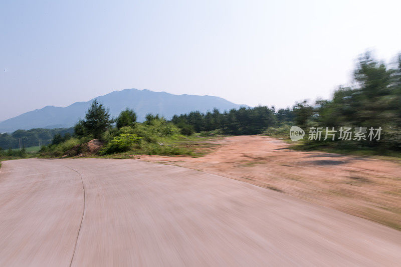 在阳光明媚的日子里，乡间小路上有绿油油的草地