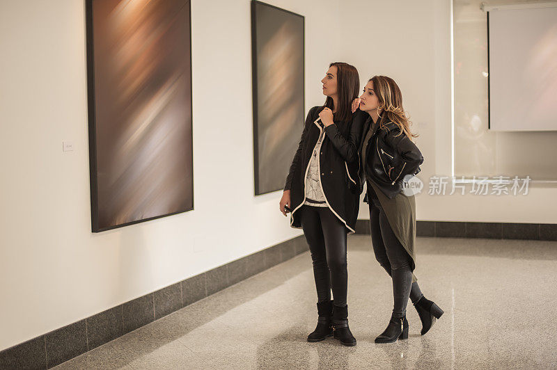 两个女朋友在美术馆看现代绘画