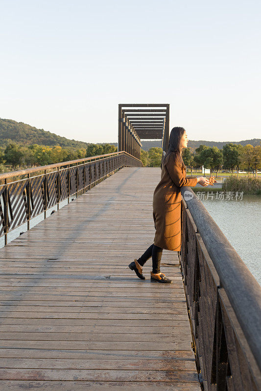 黄昏时分，一个若有所思的女人站在桥上