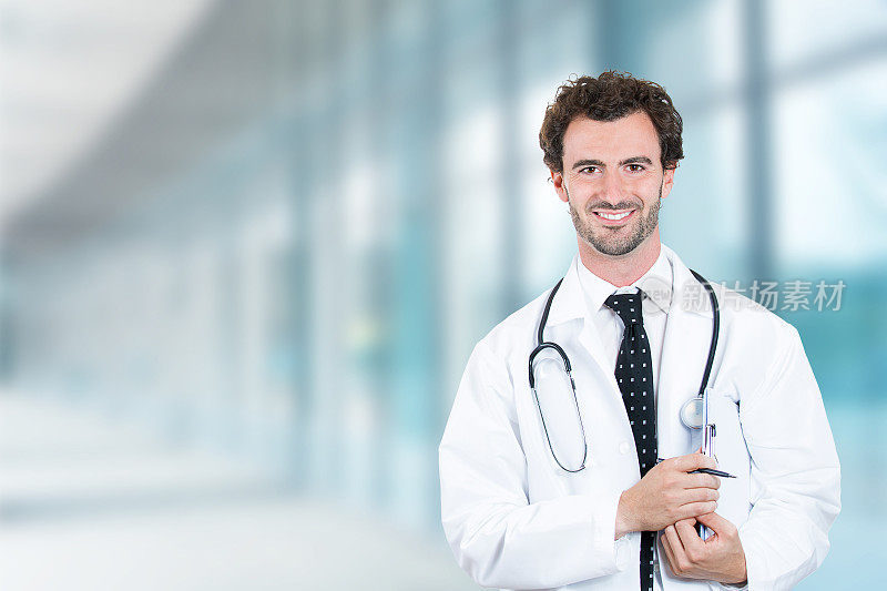 肖像友好的男医生微笑着站在医院走廊诊所的窗户背景