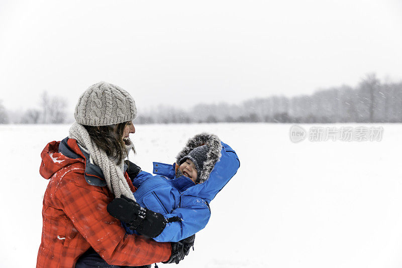 母亲和儿子在冬季森林暴风雪