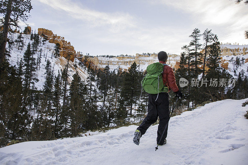 冬季徒步旅行者用冰爪在雪山景观上行走