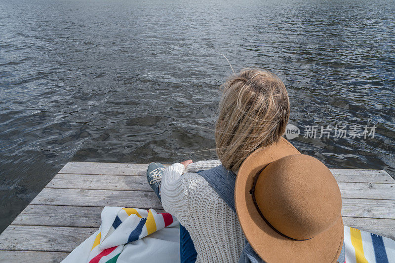 年轻女子在湖边码头凝望大自然