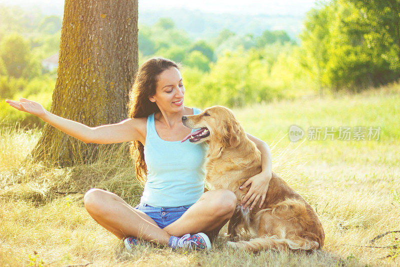 一个年轻女人和她的狗玩得很开心