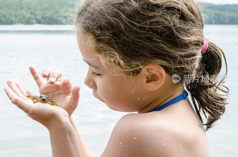 近距离小女孩在户外暑假爱抚一只真正的青蛙