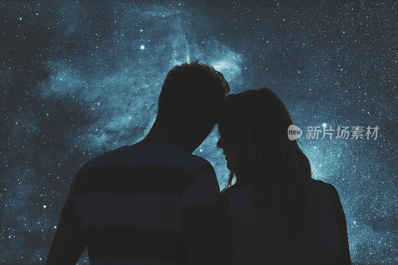 星空下一对年轻夫妇的剪影。我的天文工作。