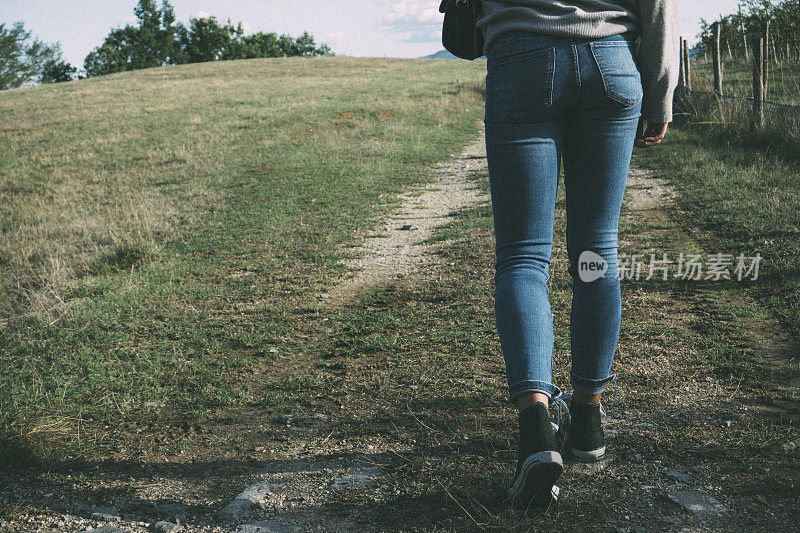 一个年轻女子独自走在乡间小路上