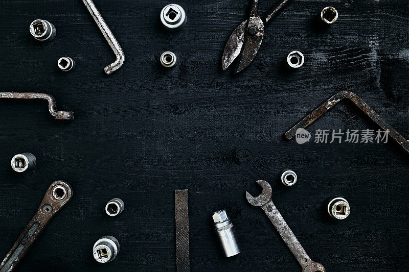 旧的生锈的工具放在一张木桌上。锤子，凿子，金属剪刀，扳手，凿子