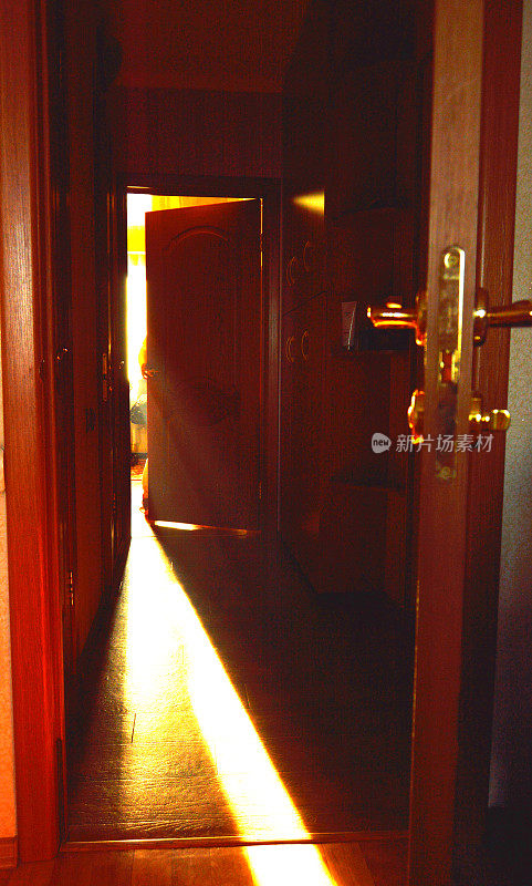一束光穿过房间敞开的门落在地板上