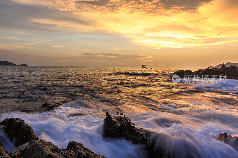 海浪在岩石上的海景，长时间暴露在泰国普吉岛海滩上的日落。