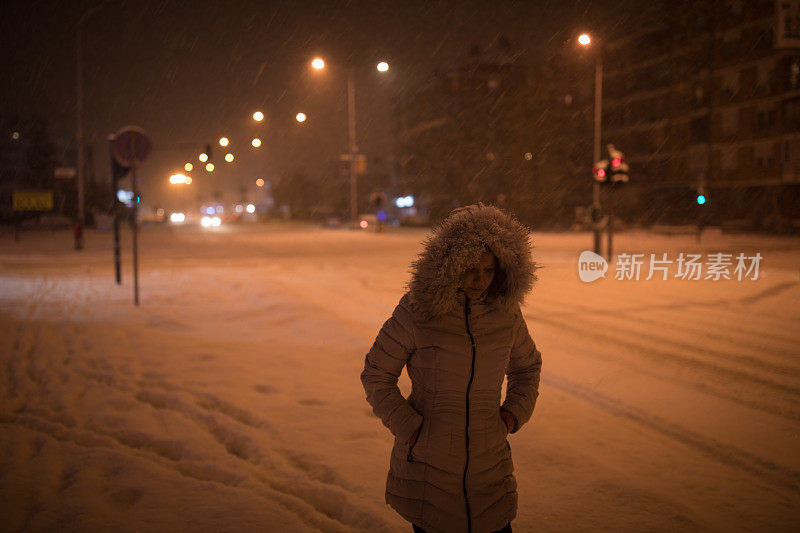 一个女人在下雪的晚上散步