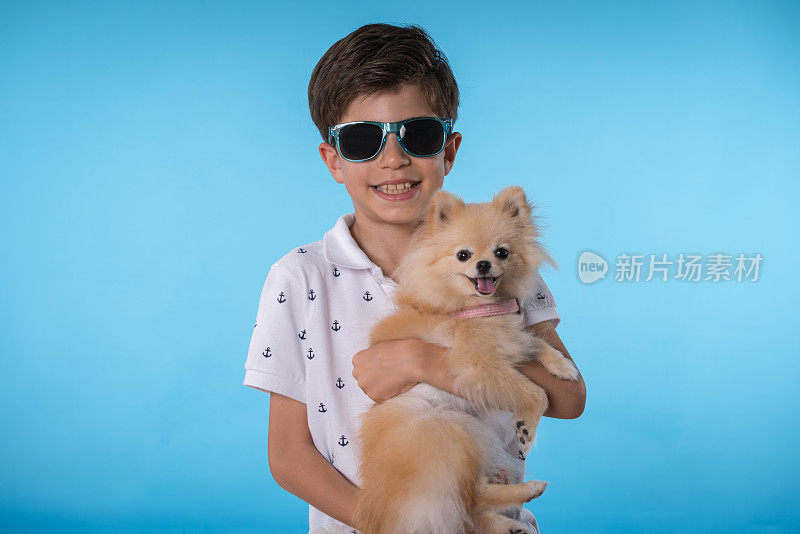 快乐的男孩和她的博美犬斯皮茨型狗