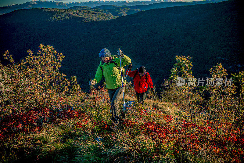 高级夫妇在秋天的黎明徒步旅行在南朱利安阿尔卑斯山，意大利-斯洛文尼亚，欧洲