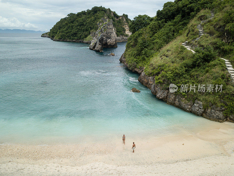 鸟瞰热带海滩上的年轻情侣享受度假和大自然，人们旅游探险的理念