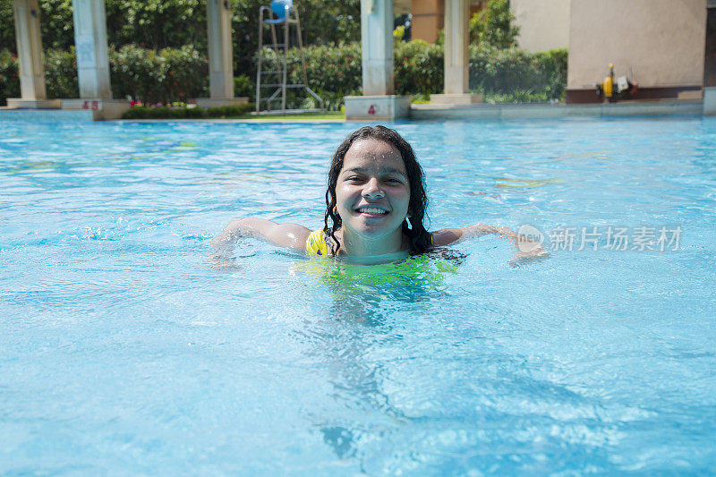 一个可爱的年轻女孩的肖像在游泳池-股票图像