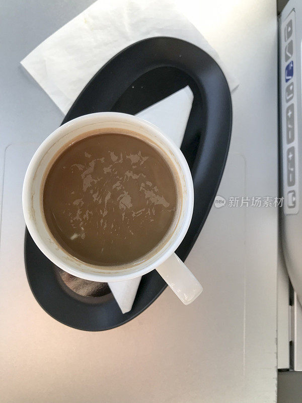 一杯热牛奶咖啡在飞机高视角上喝