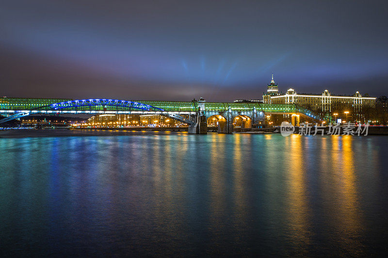 黄昏时分，城中灯火通明，河上架起一座大桥。