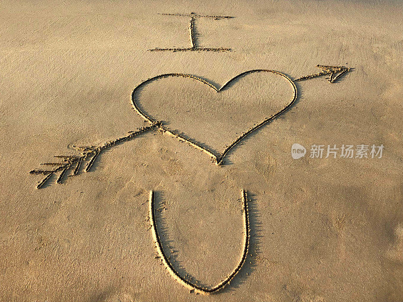图片上写在阳光明媚的海滩上与我爱的心与箭你的话写在海边的沙子，帕洛伦海滩，印度果阿，概念社交媒体照片上的手写在金色的沙子与现代标签前缀