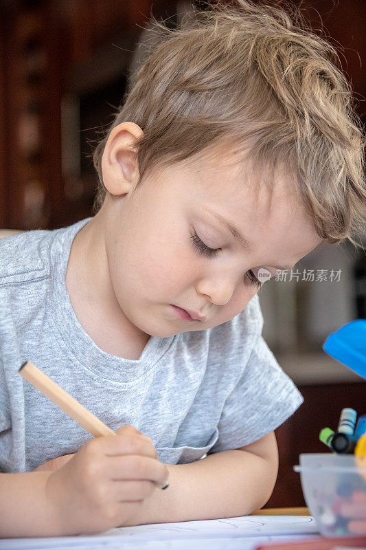 一个三岁的男孩正在做作业