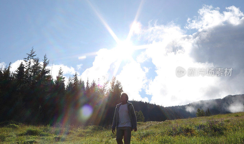 晨曦中，人们走过山间草地