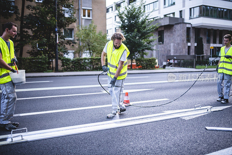 熟练的道路工作人员喷涂箭头标记