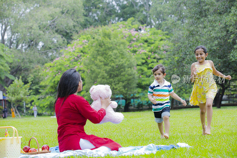 快乐的家庭享受野餐在自然在夏季股票照片