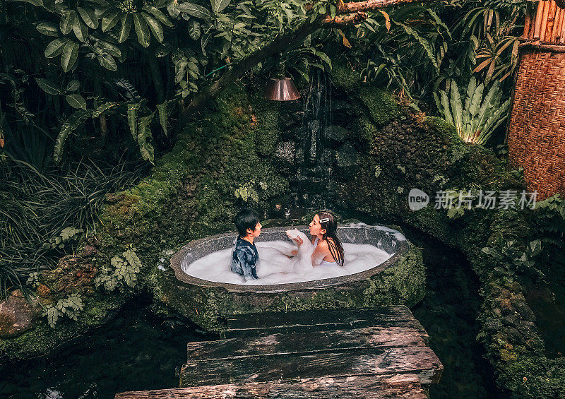 夫妇在户外沐浴与热带丛林豪华水疗酒店，生活方式