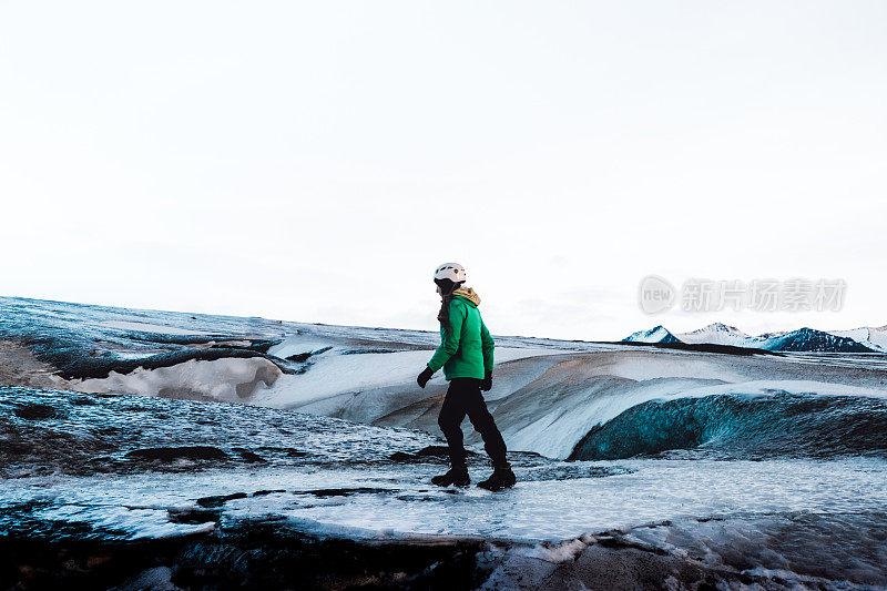 戴着头盔的女人在冰岛Vatnajökull冰川上徒步旅行