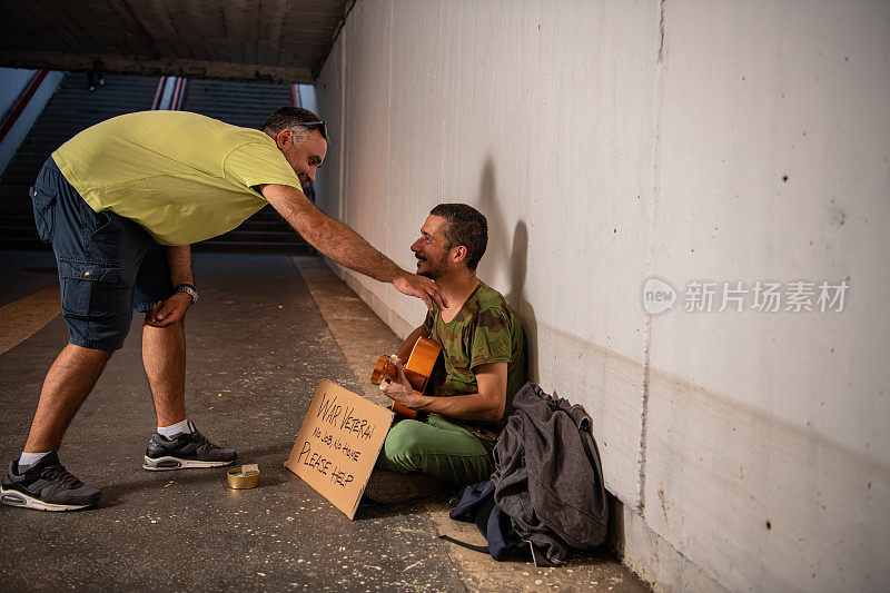 一个人在街上帮助一个乞丐