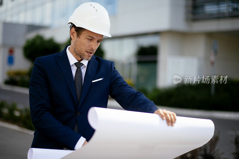 年轻的男工程师在一个建筑工地库存照片