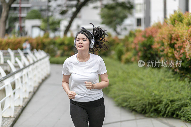 一个年轻女子在公园里跑步和锻炼