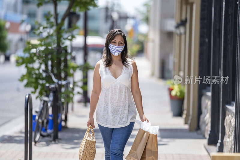 一名西班牙妇女戴着防护面具在市中心购物