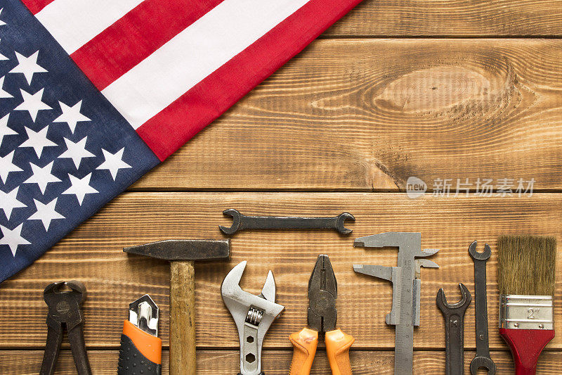 劳动节。美国国旗和各种工具放在一张木桌上。