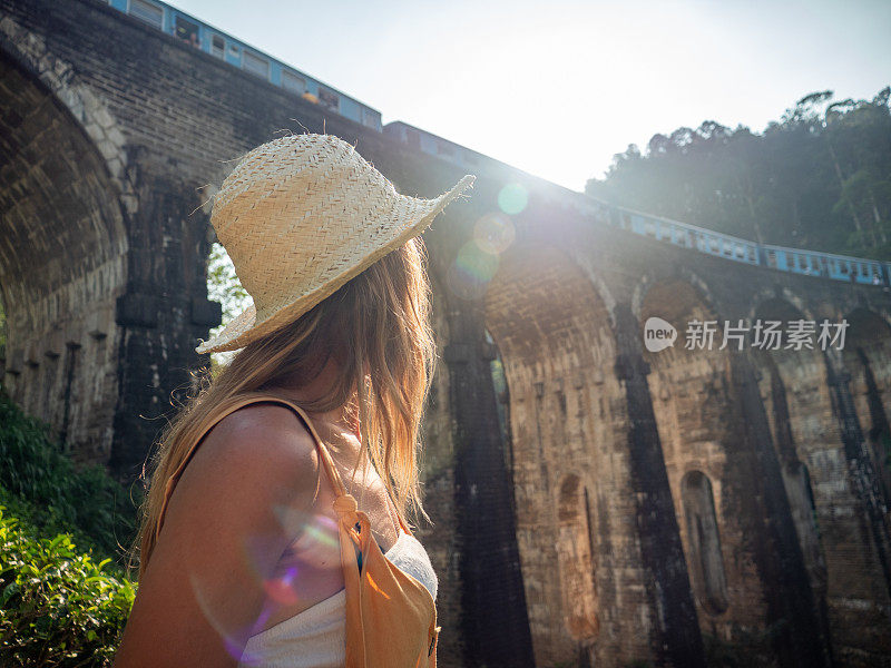 女游客在日落时凝视着著名的大桥