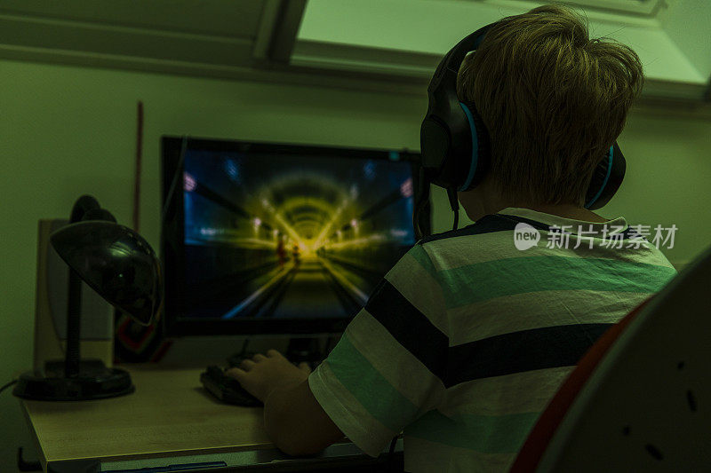 一个玩电脑游戏的青少年的后视图